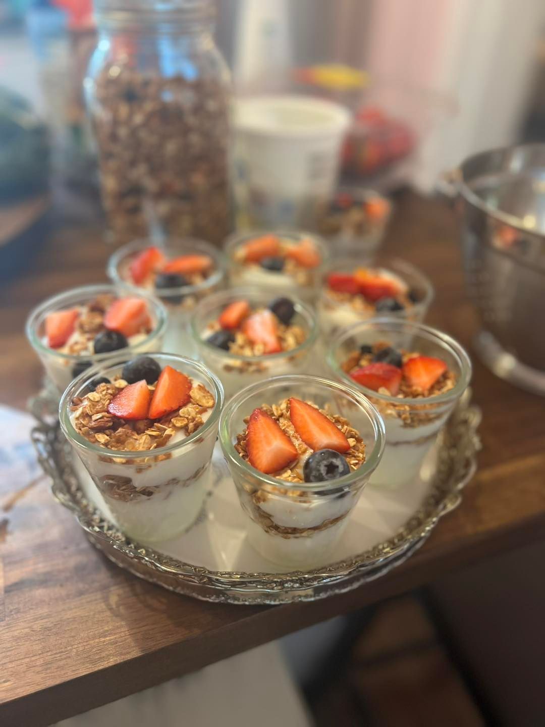 A tray of desserts with strawberries and blueberries on a wooden table.