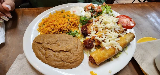 A plate of Mexican food: rice, beans, flauta with cheese, tomato, guacamole, sour cream.