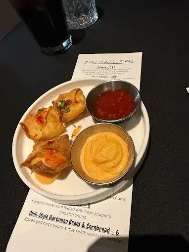 Appetizers: fried dumplings with dipping sauces on a white plate, menu below.