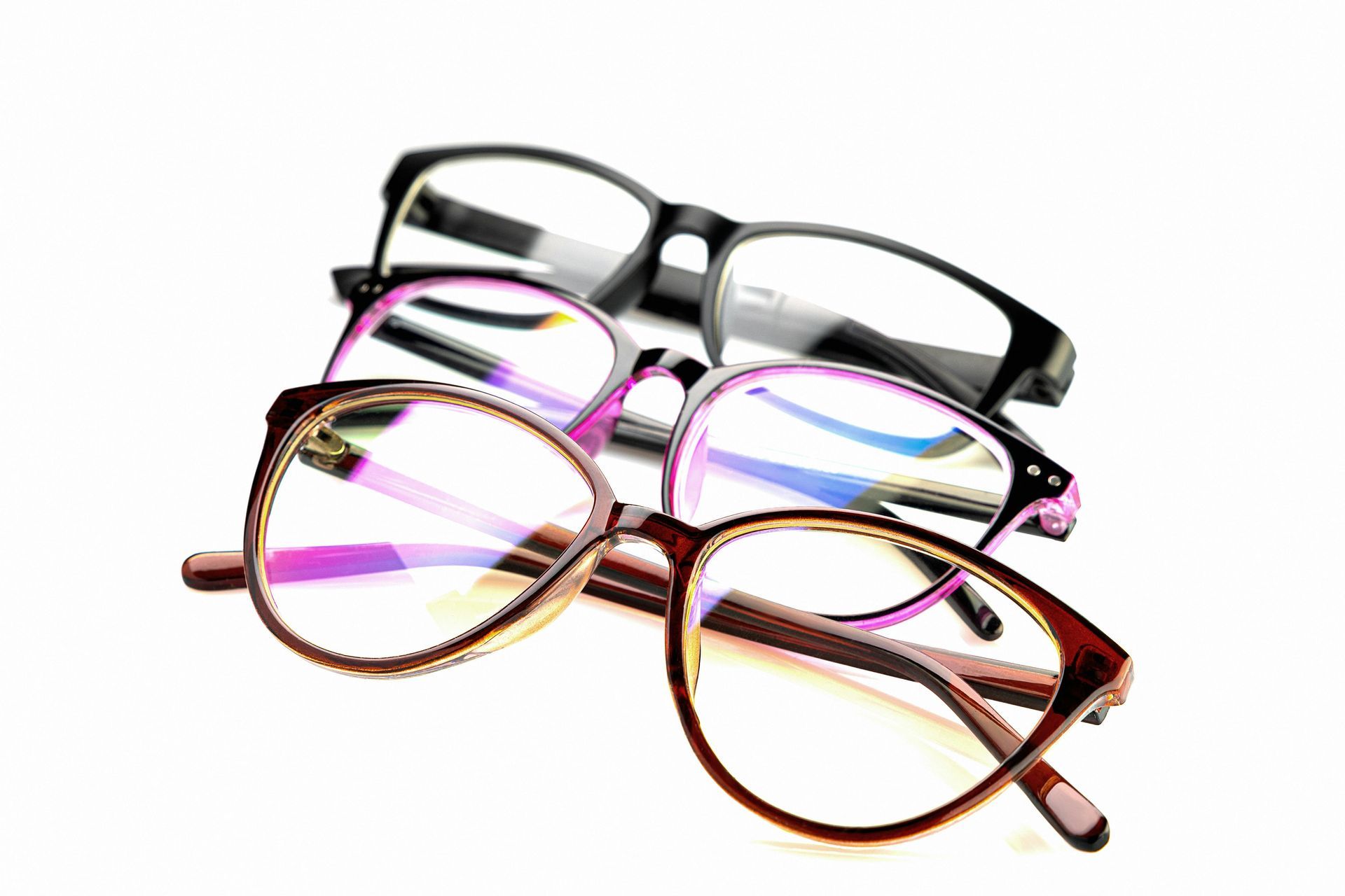 Four pairs of eyeglasses with black, silver, pink, and brown frames on a white background