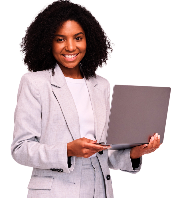 Mulher de cabelos cacheados, vestindo um terno cinza claro, sorrindo e segurando um laptop.