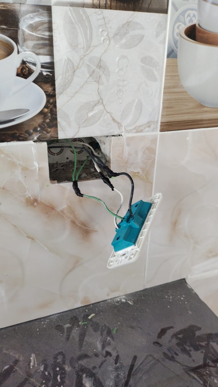 Interruptor eléctrico con cables expuestos y cubierta faltante, instalado en una pared de azulejos.