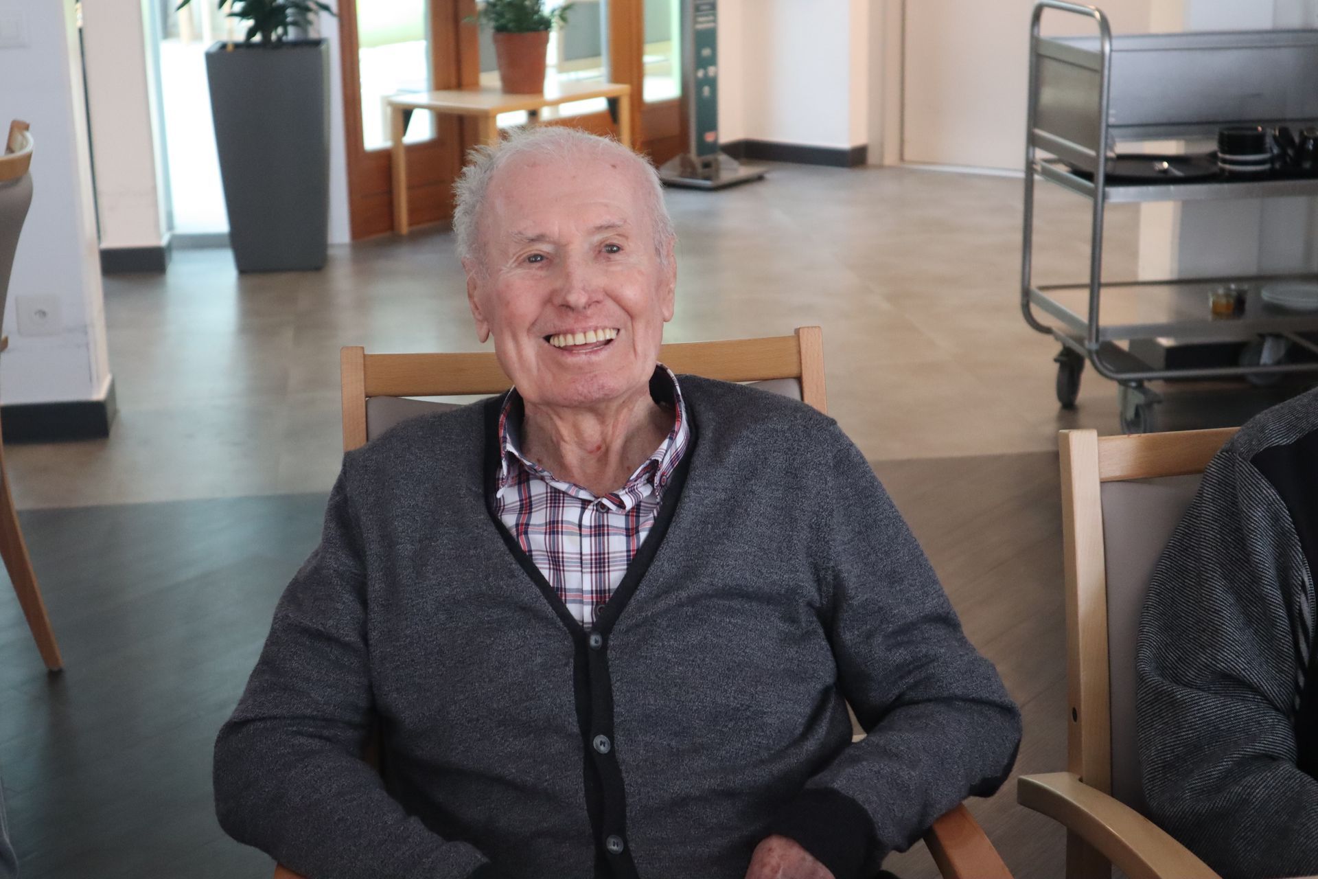 Un homme en fauteuil roulant est assis à côté d'un homme qui joue du piano.