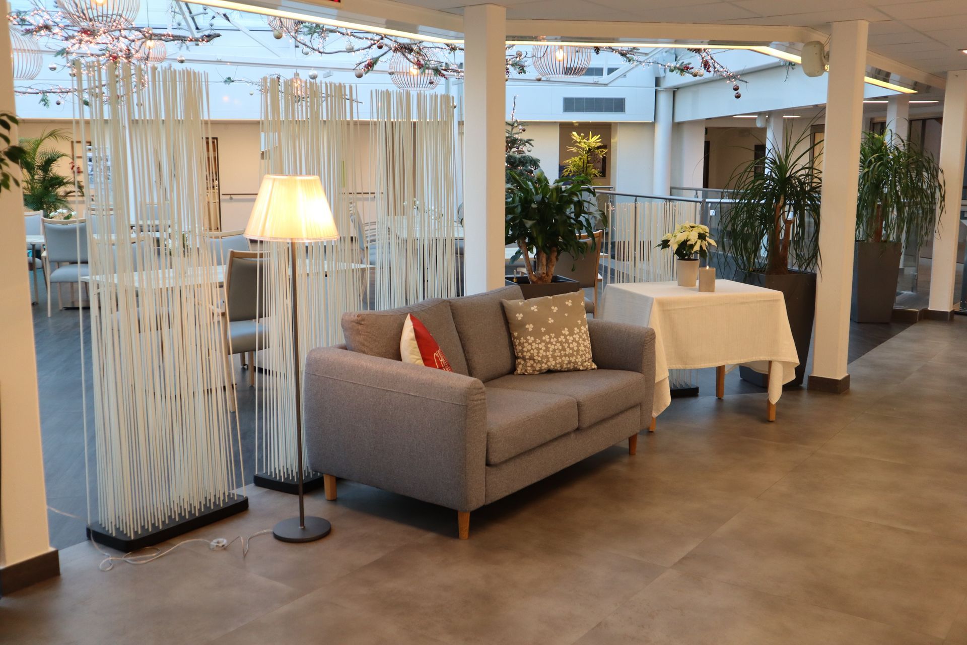 Un salon avec un canapé , une table , des chaises et des plantes .