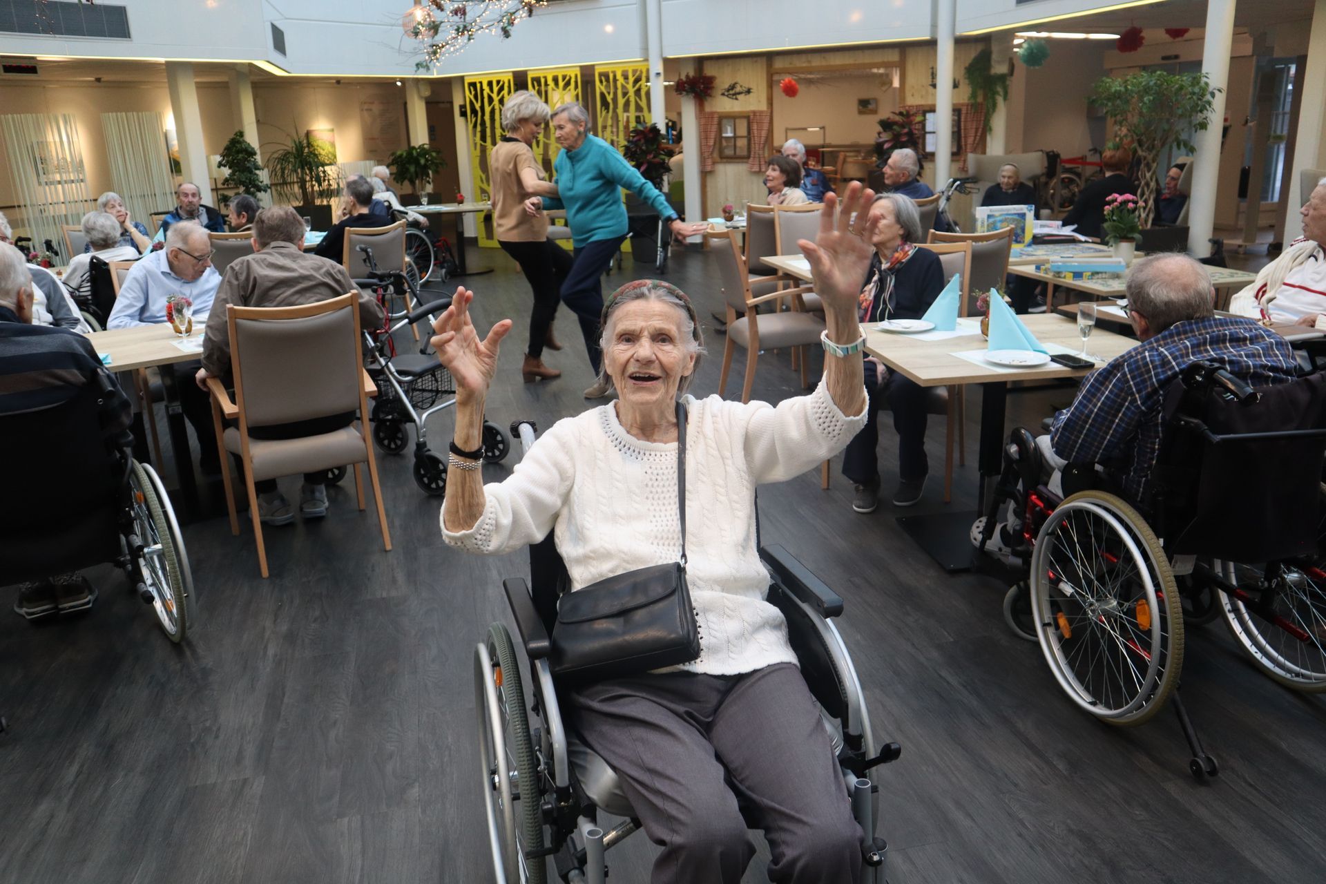 Une soignante enlace un homme plus âgé dans un salon.