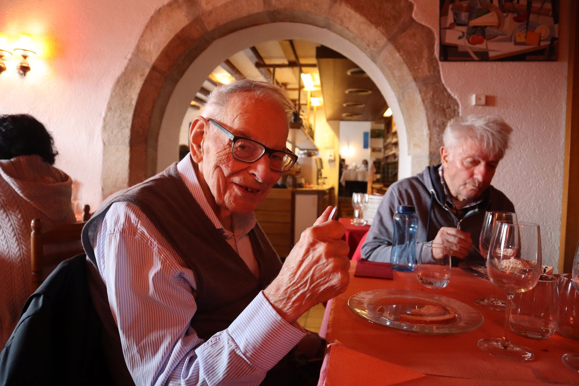 Un homme âgé est assis à une table en train de faire du collage.