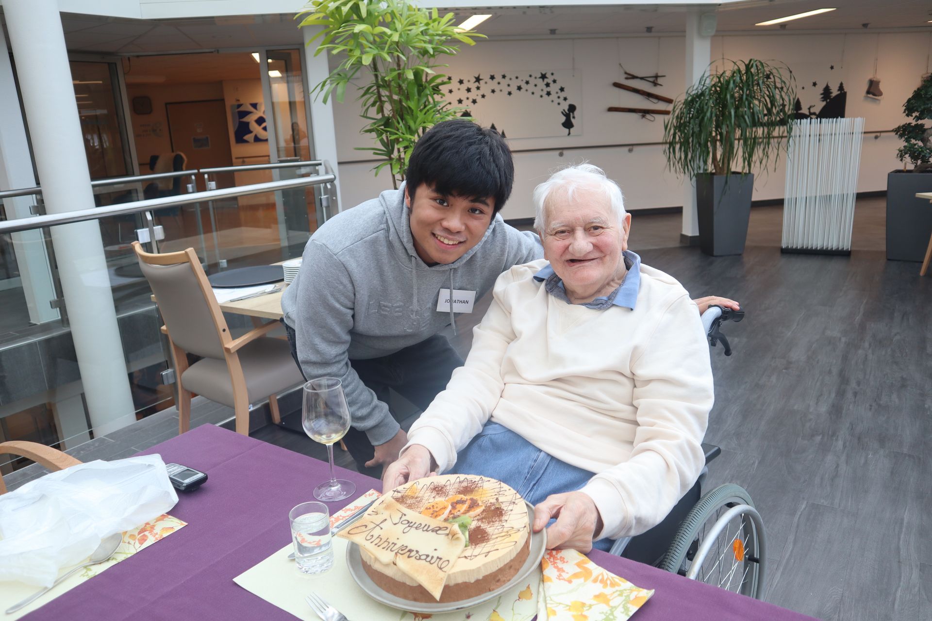 Une femme aide un homme âgé à colorier.