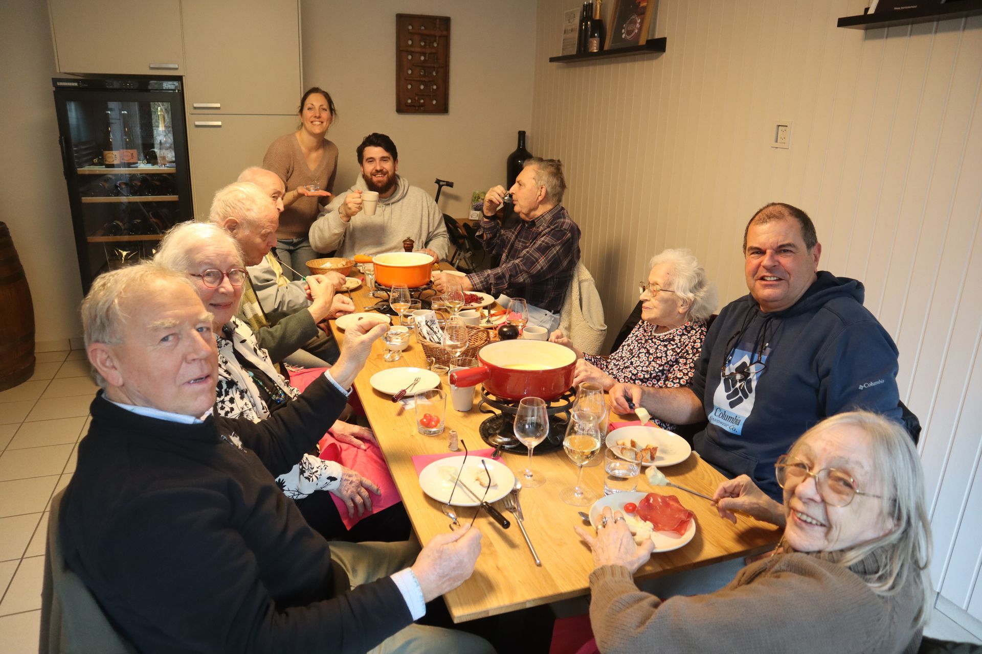 Un groupe de personnes sont assises autour d'une table en train de manger de la nourriture.