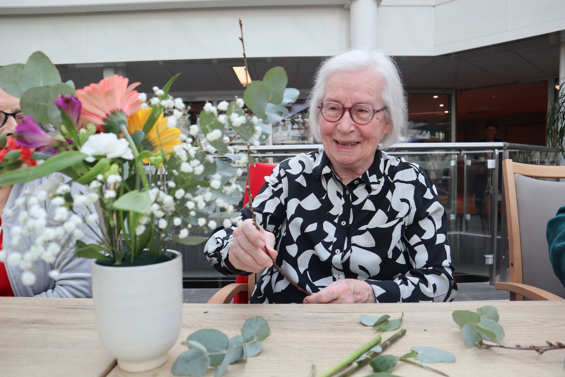 Deux femmes sont assises à une table en train de peindre.