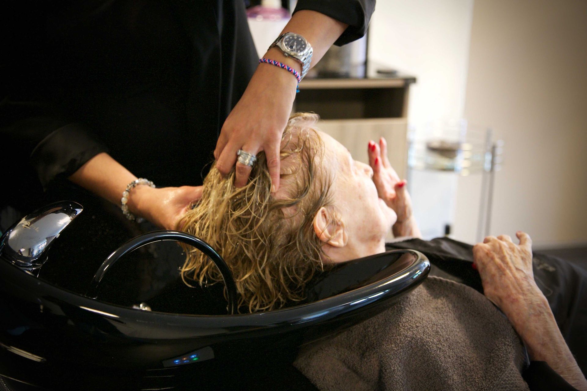 Une femme se fait laver les cheveux dans un salon.