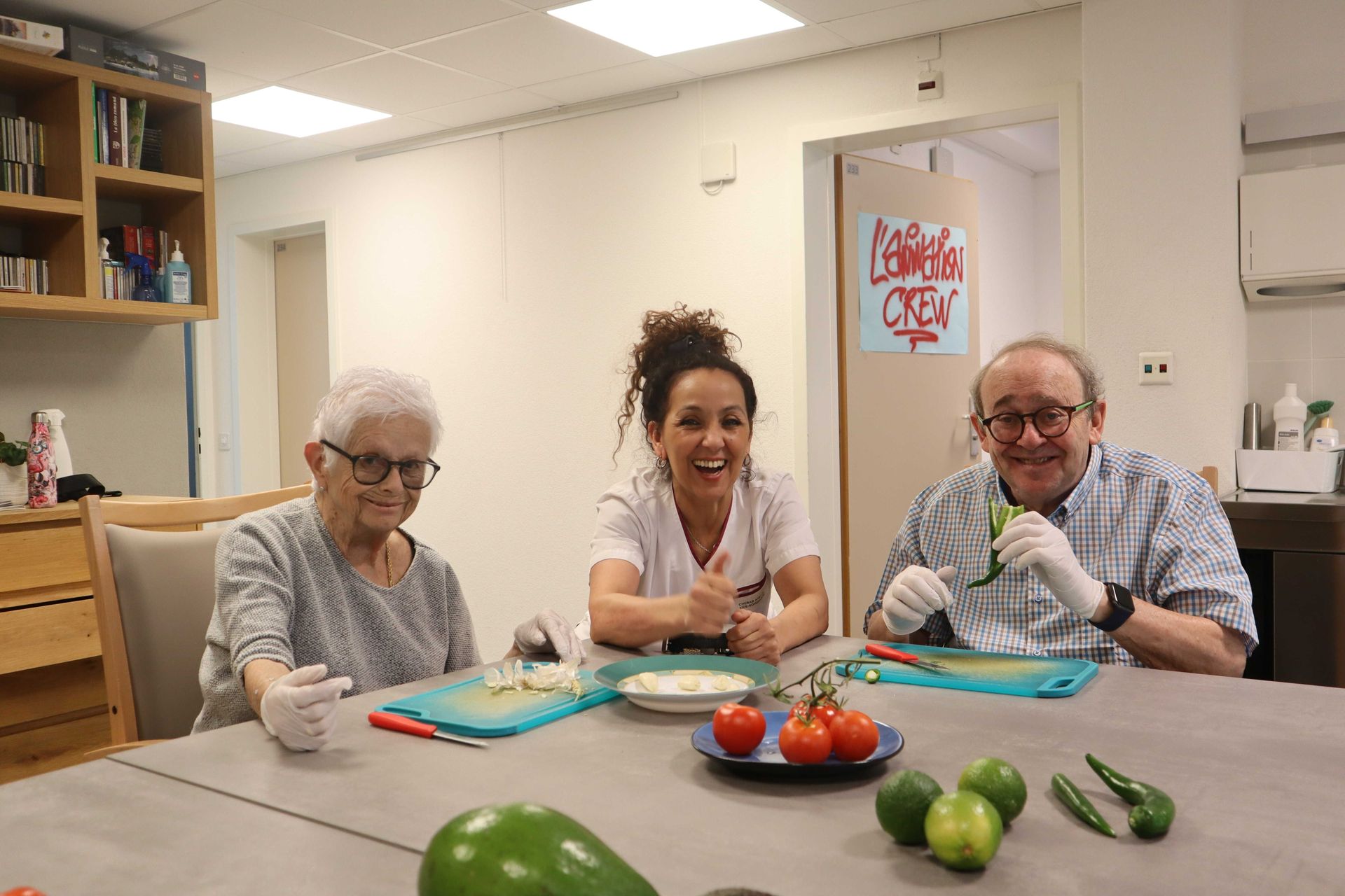 Une soignante est assise à côté d'une femme plus âgée sur un canapé.