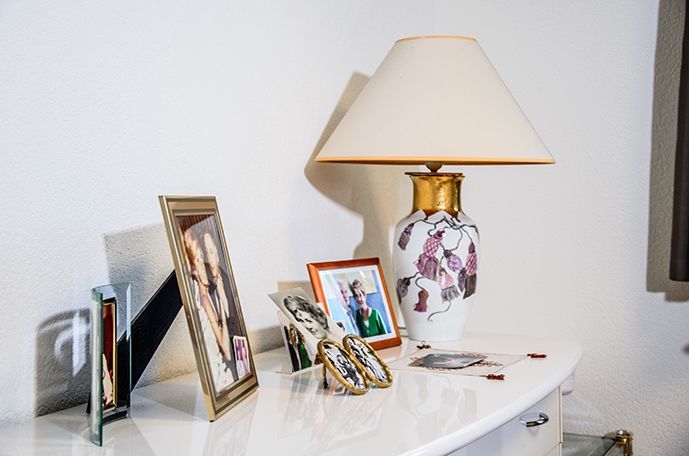 Un buffet avec une lampe et des cadres photos posés dessus.