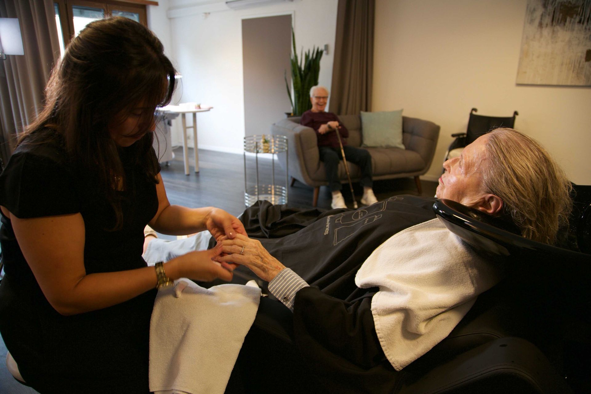 Une femme âgée se fait faire les ongles par une femme dans un salon.