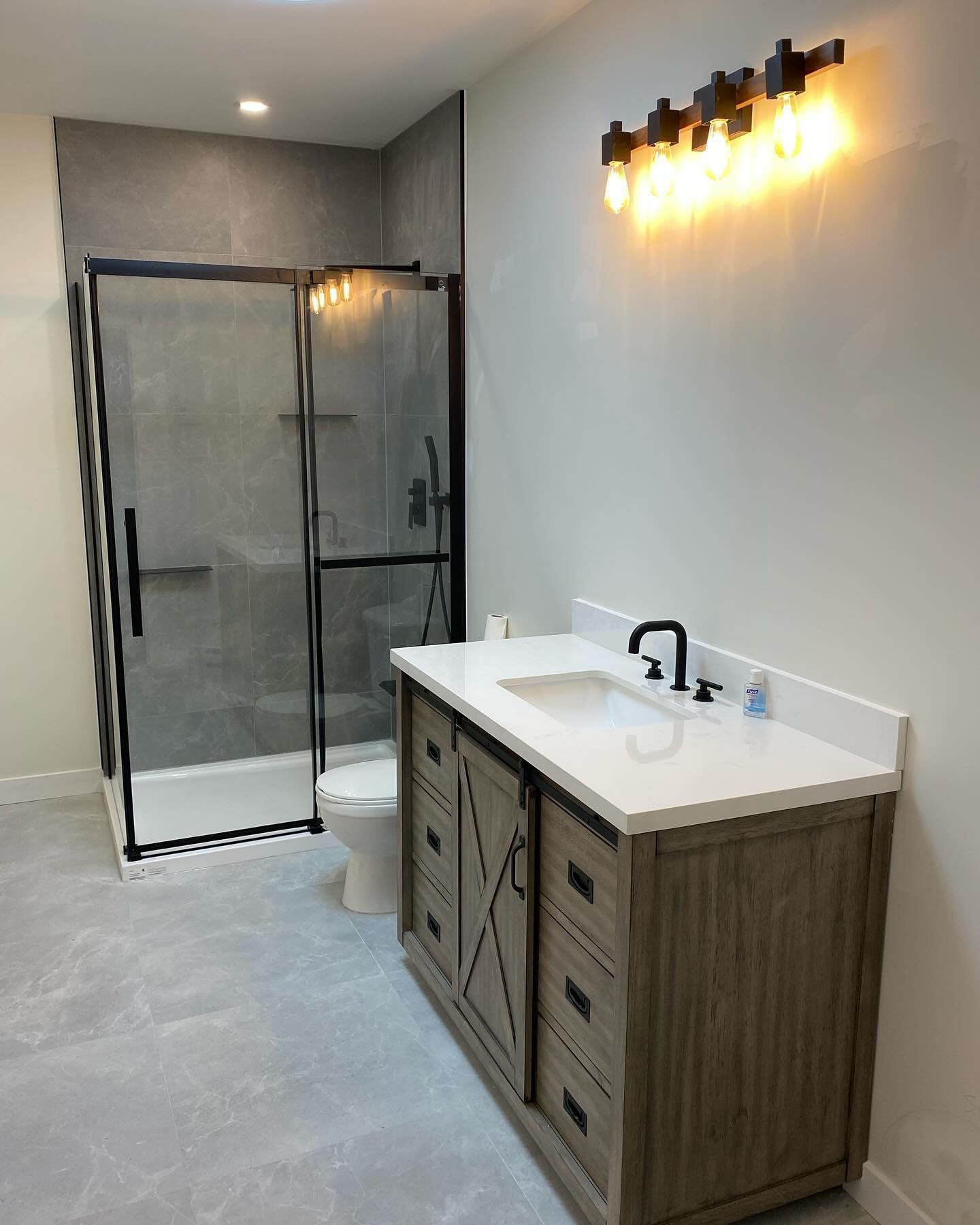 Une salle de bain avec lavabo, WC et douche.