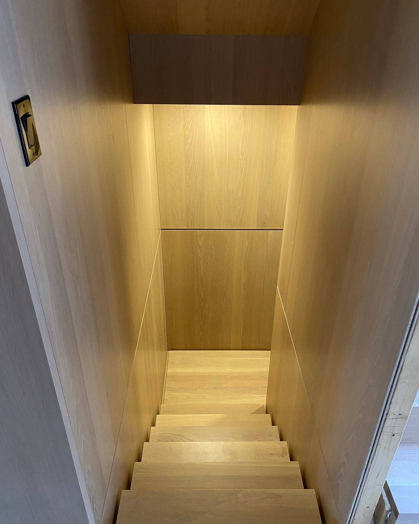 Un escalier en bois avec une lumière en bas