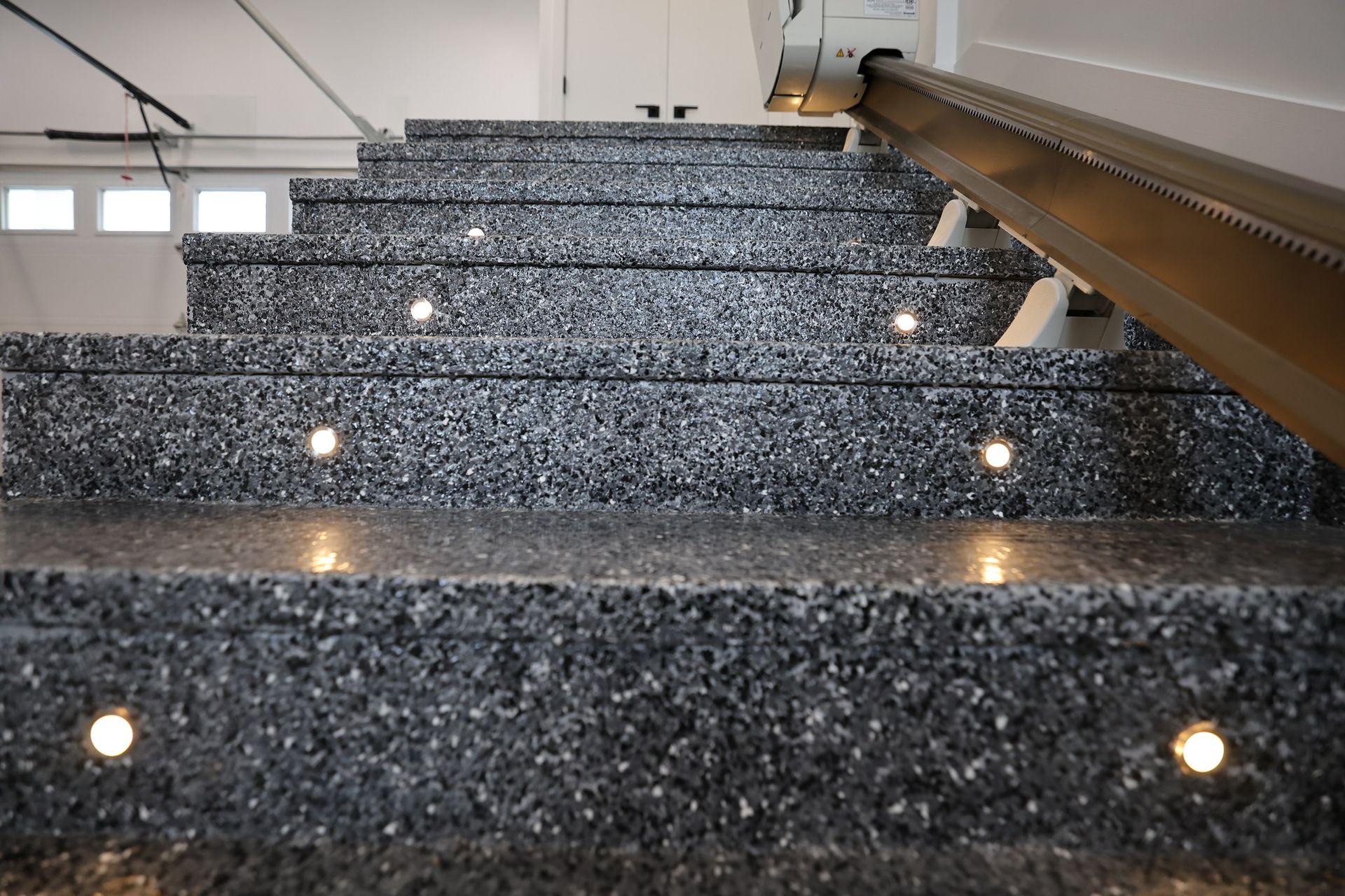 Un escalier en granit avec des lumières sur les marches