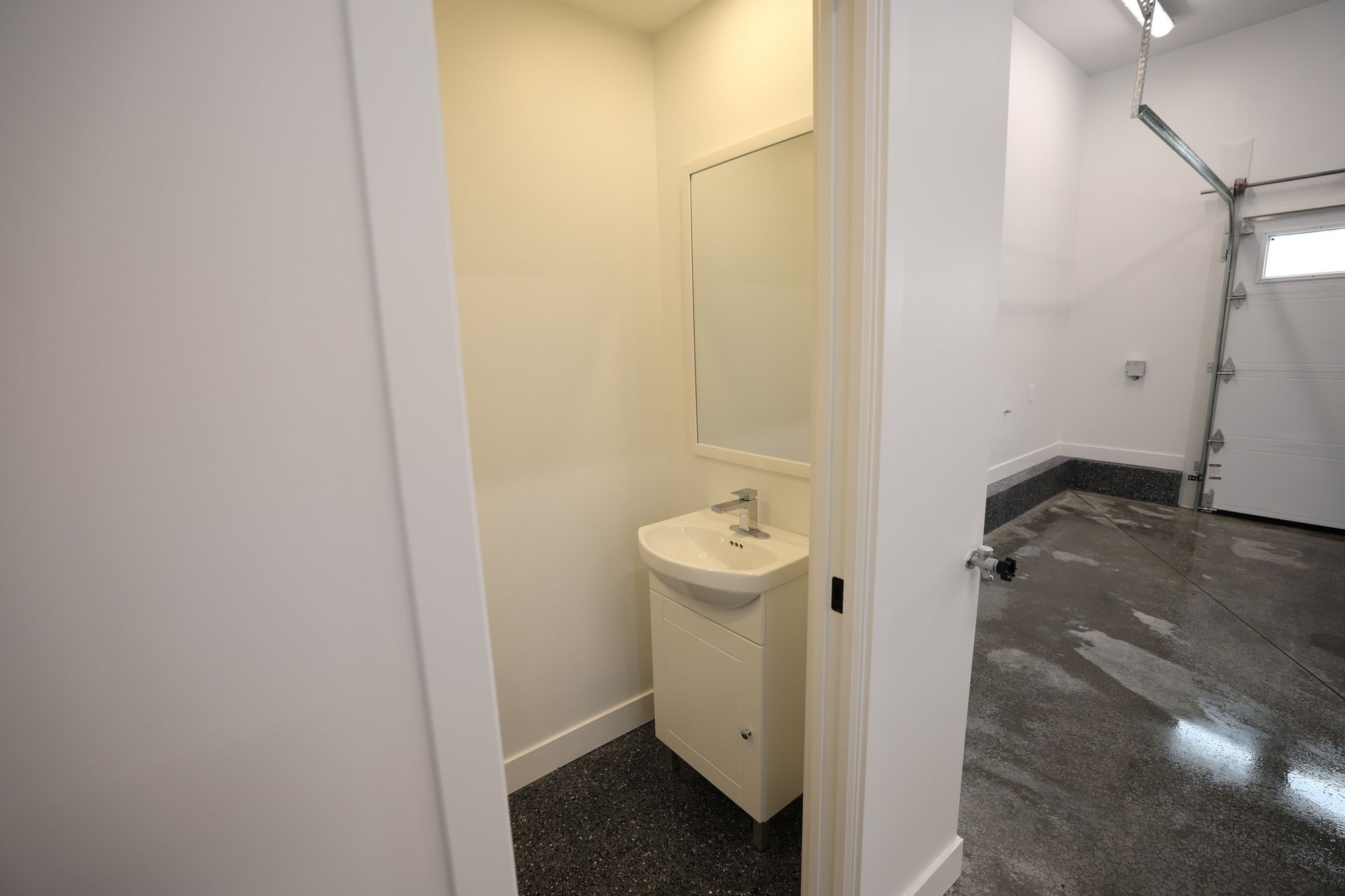 Une salle de bain avec un lavabo et un miroir dans un garage.