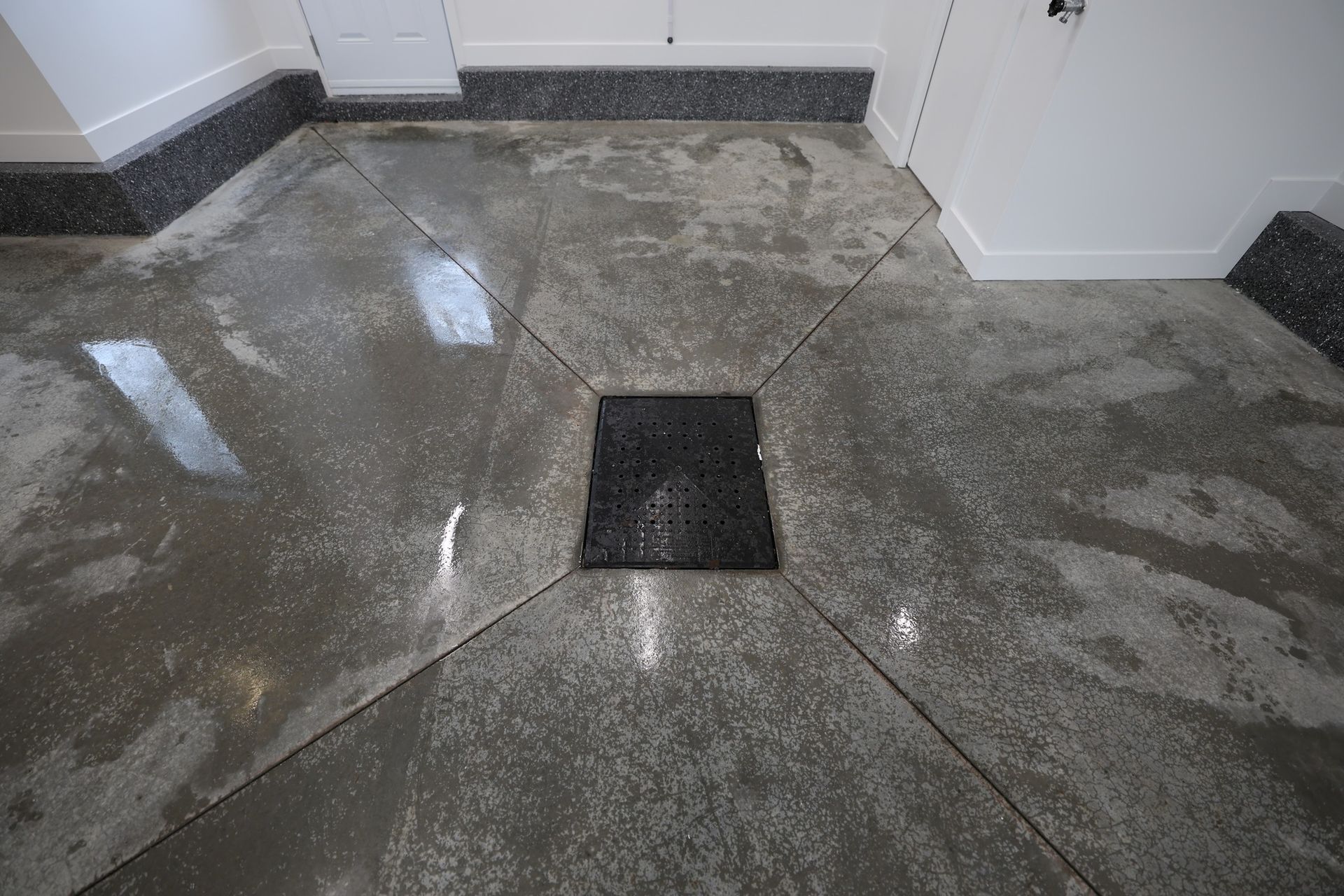 Un sol en béton avec un carré noir au milieu.