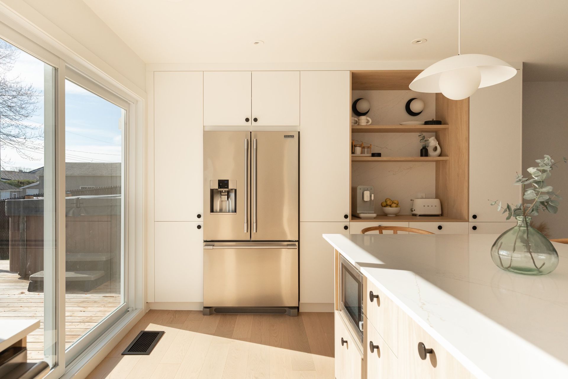 Une cuisine avec des appareils électroménagers en acier inoxydable et des armoires blanches.