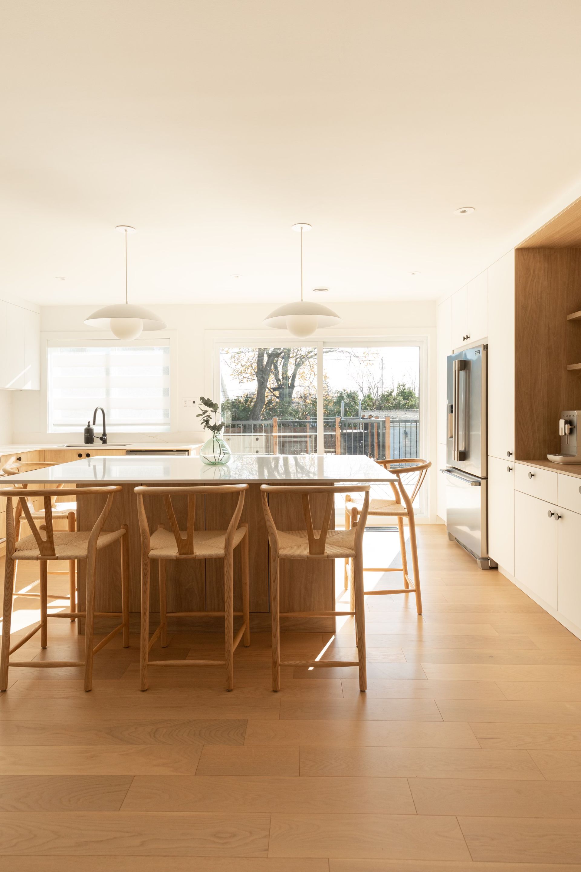 Une cuisine avec un grand îlot, des tabourets et un réfrigérateur.