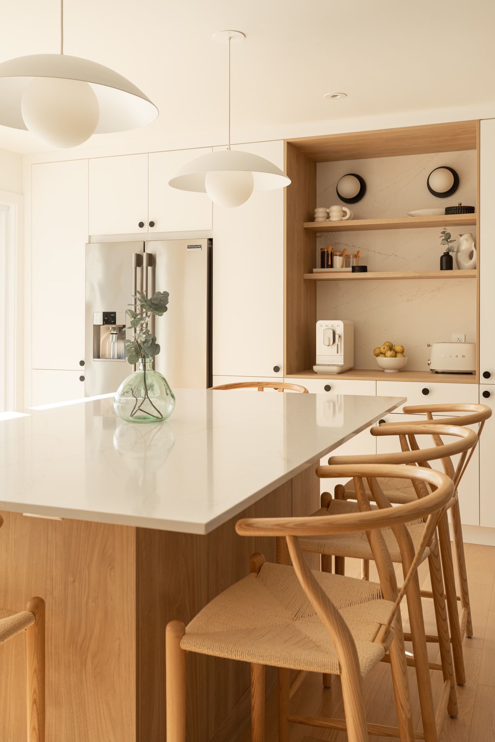 Une cuisine avec une table et des chaises et un vase sur le comptoir.