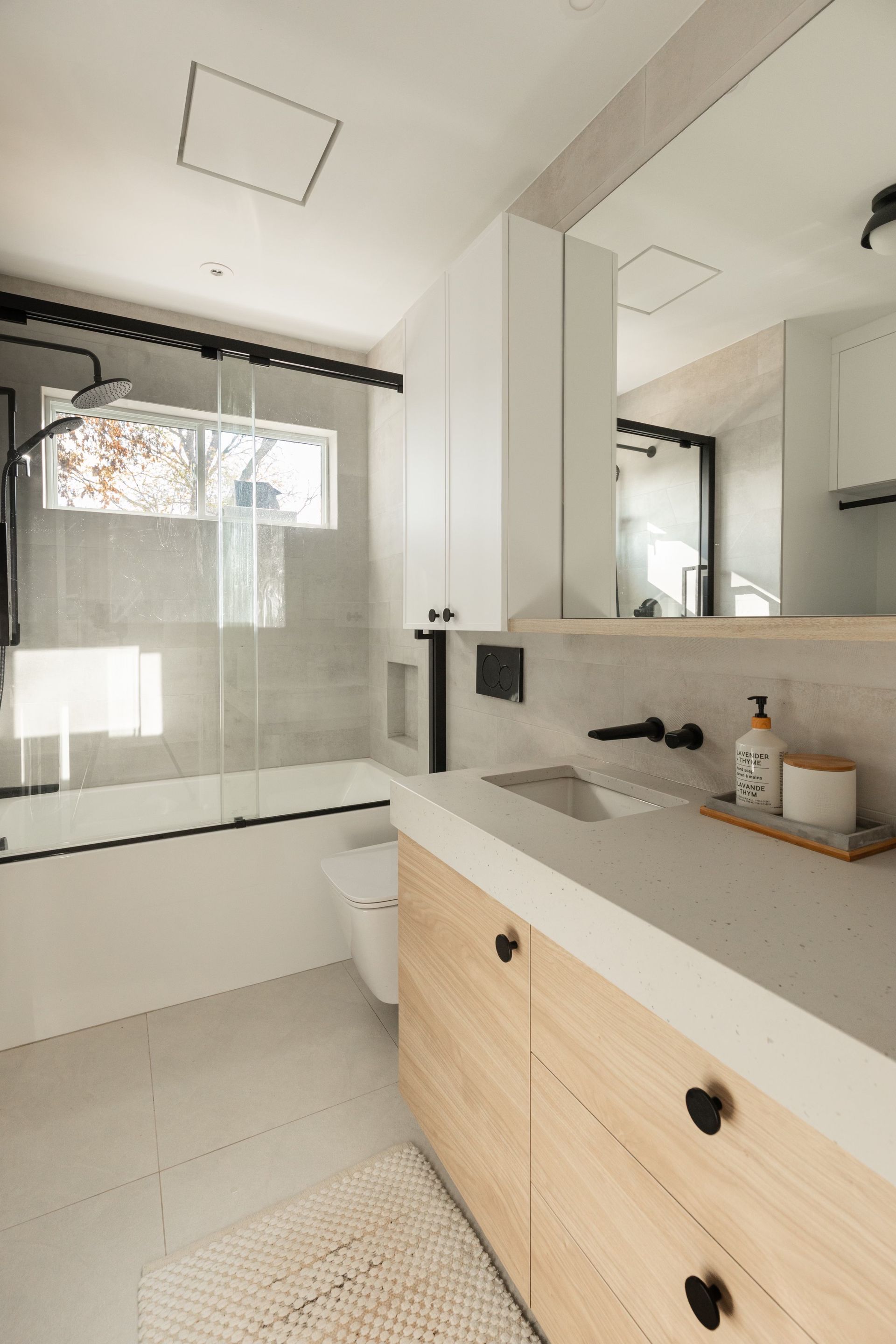 Une salle de bain avec lavabo, WC, baignoire et miroir.