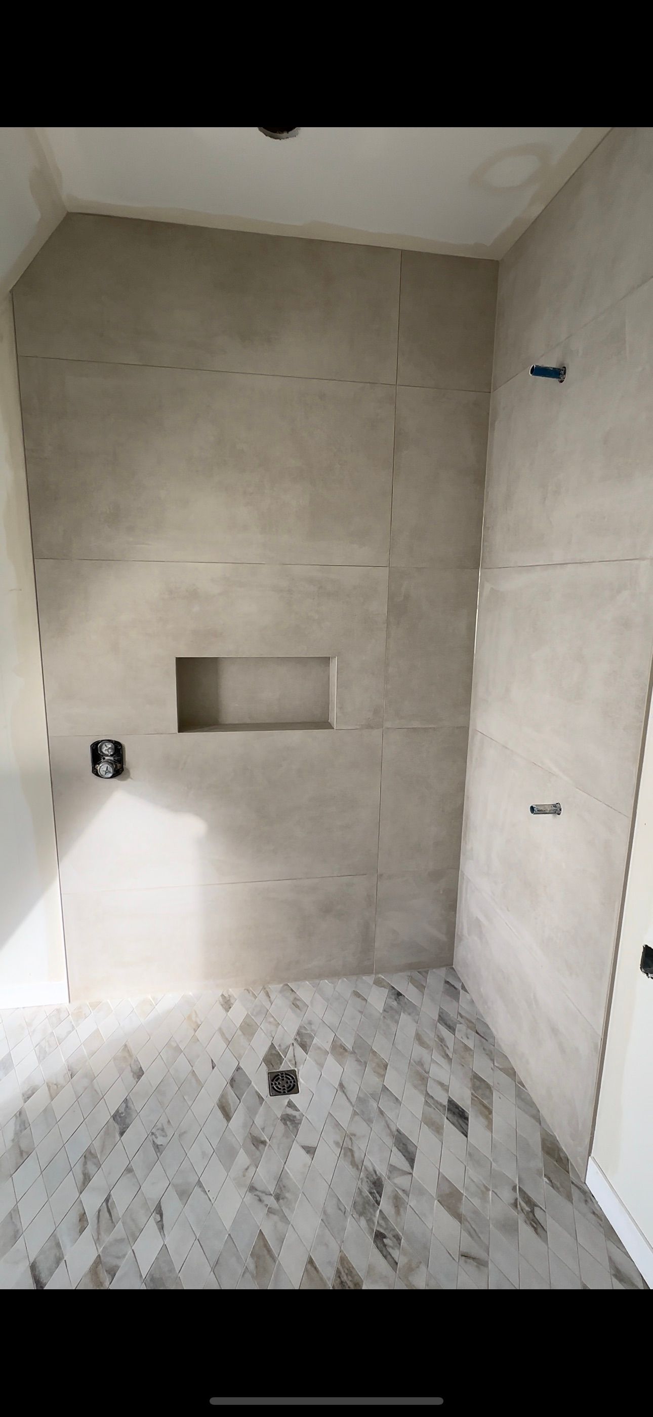 Une salle de bain avec douche à l'italienne et sol carrelé.