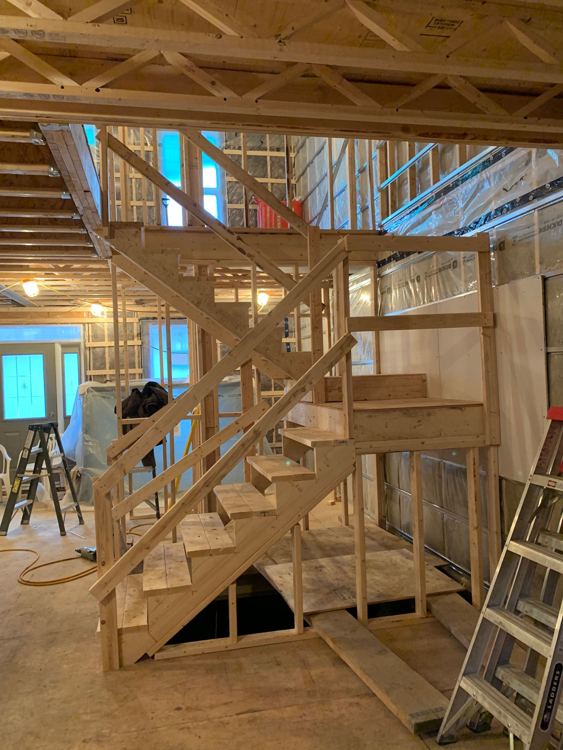 Un escalier en bois est en cours de construction dans une maison en construction.