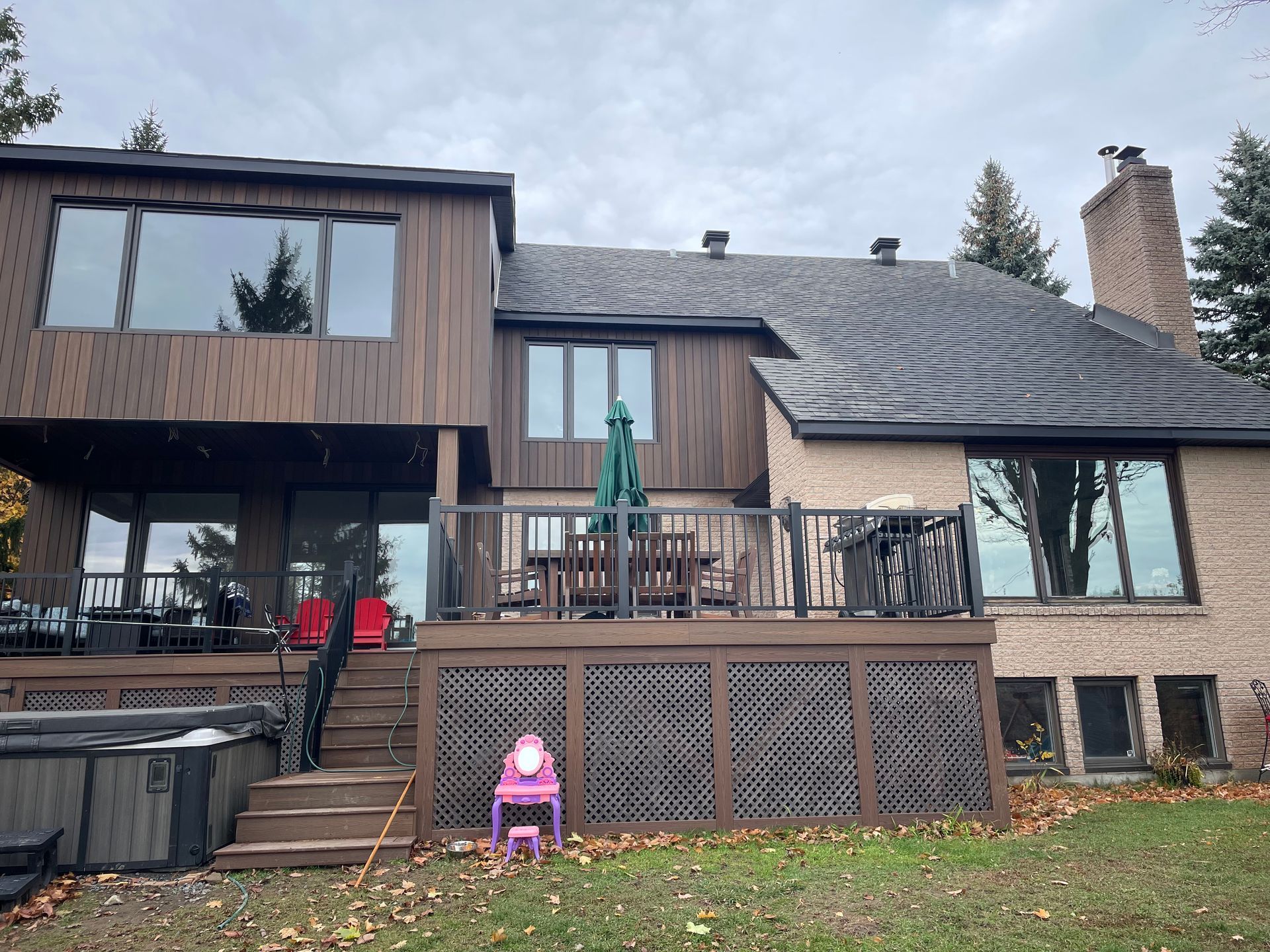 Une grande maison avec une grande terrasse et un jacuzzi