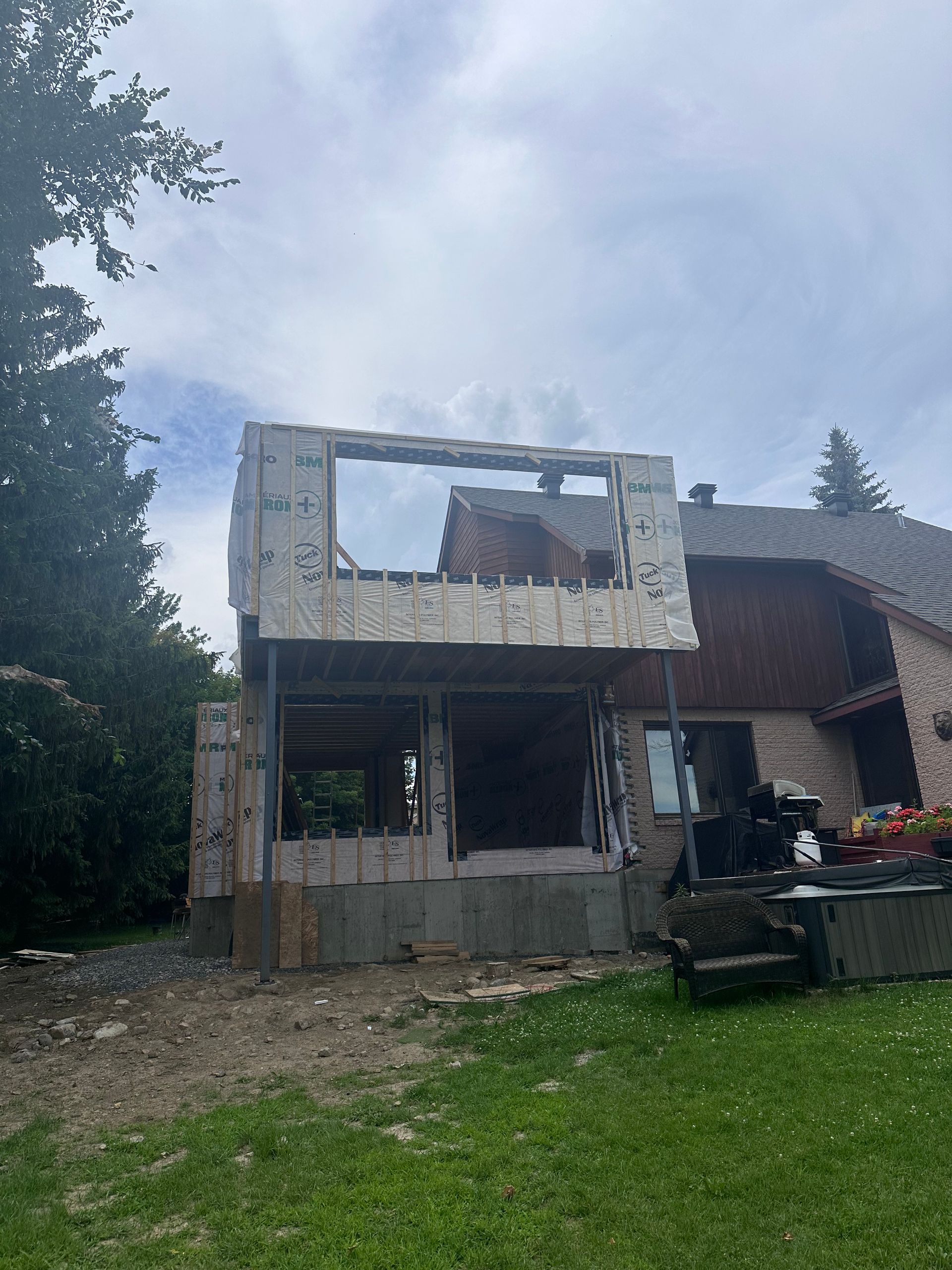 Une maison est en cours de rénovation dans une cour arrière.