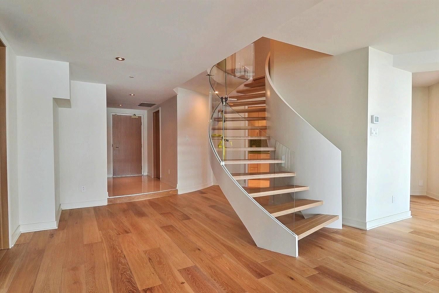 Une pièce vide avec un escalier en colimaçon et du parquet