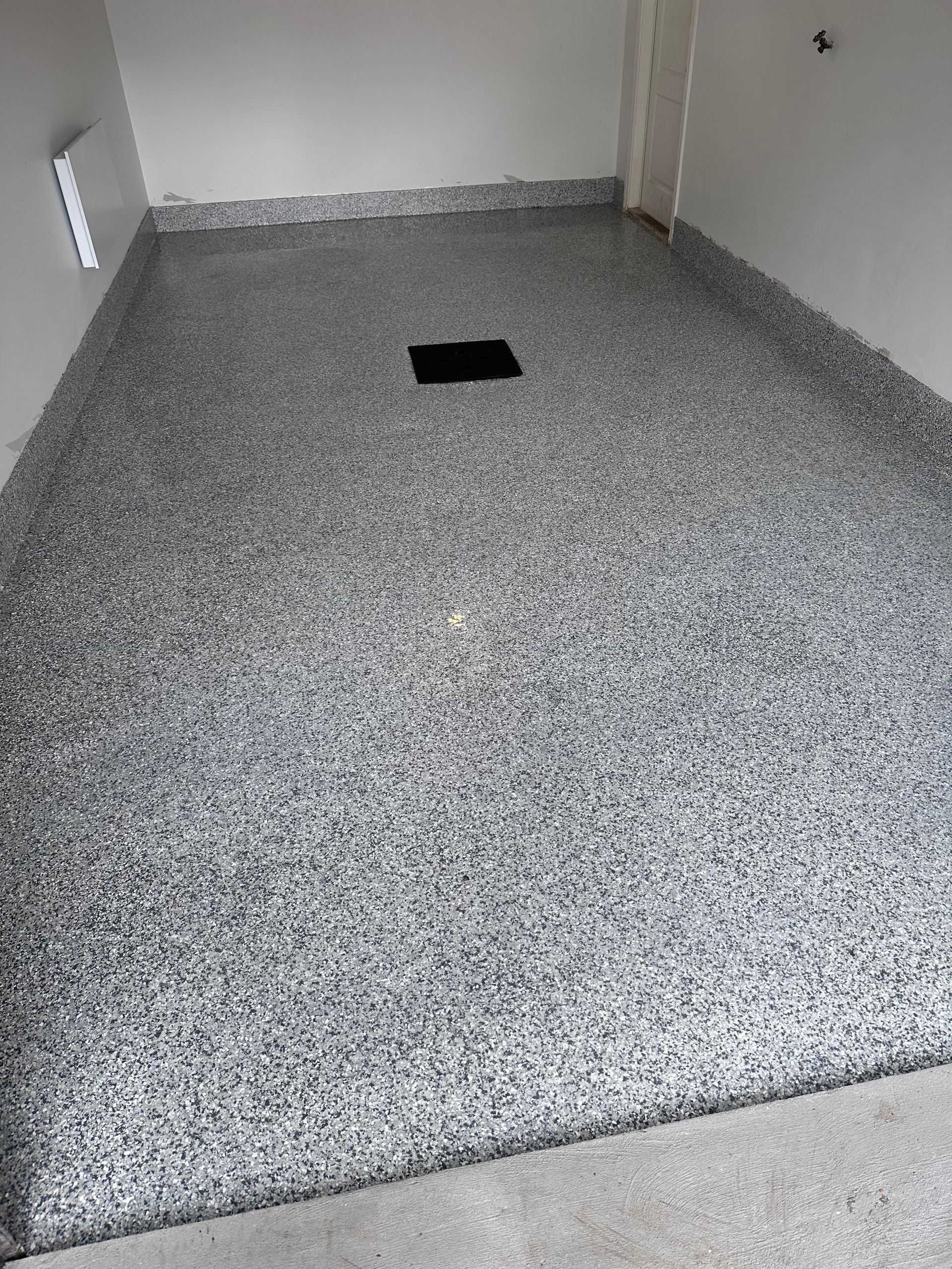 Un sol de garage avec un trou au milieu.