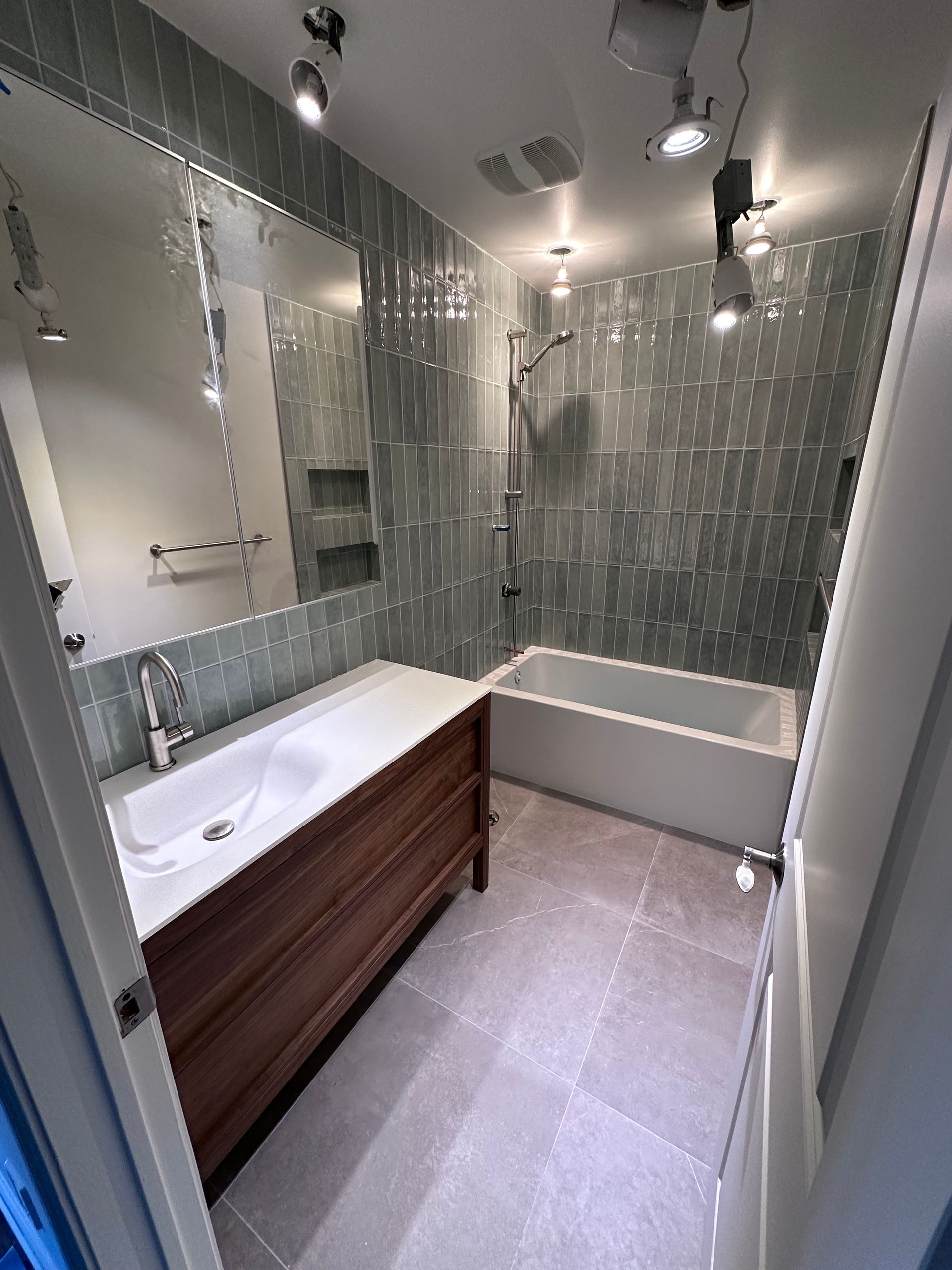 Une salle de bain avec lavabo, baignoire, douche et miroir.