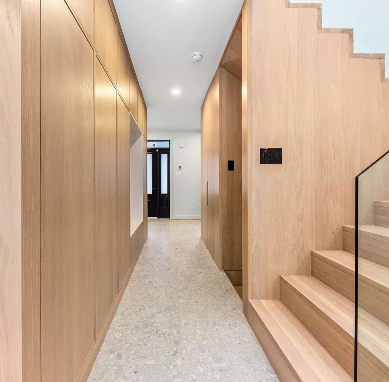 Un couloir avec des murs en bois et des escaliers dans une maison