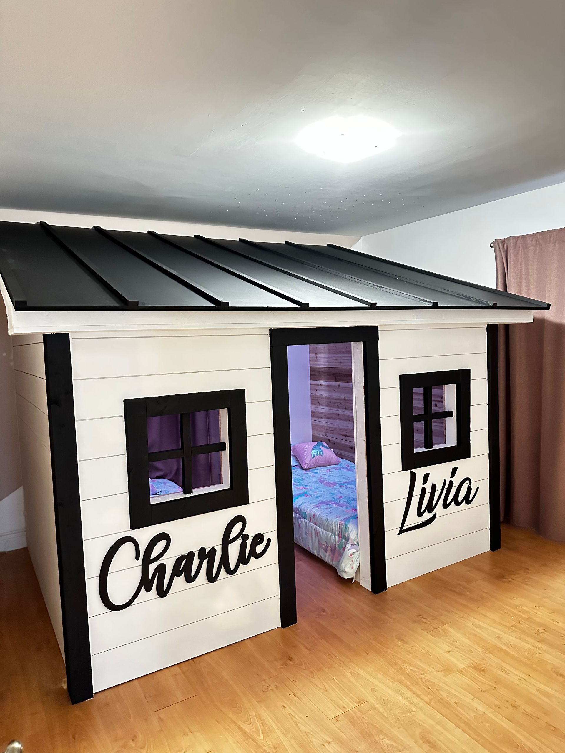 Un lit superposé est intégré au plafond d'une maisonnette.