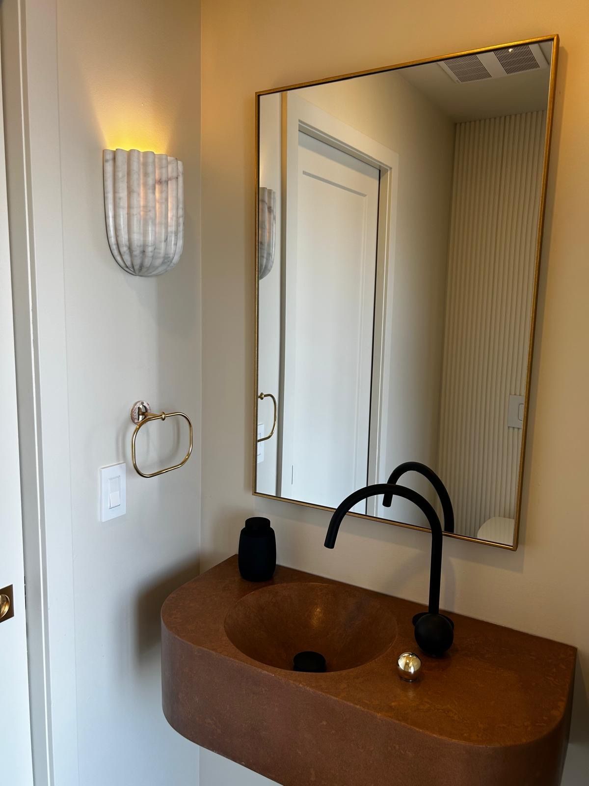 Une salle de bain avec un lavabo et un miroir au mur