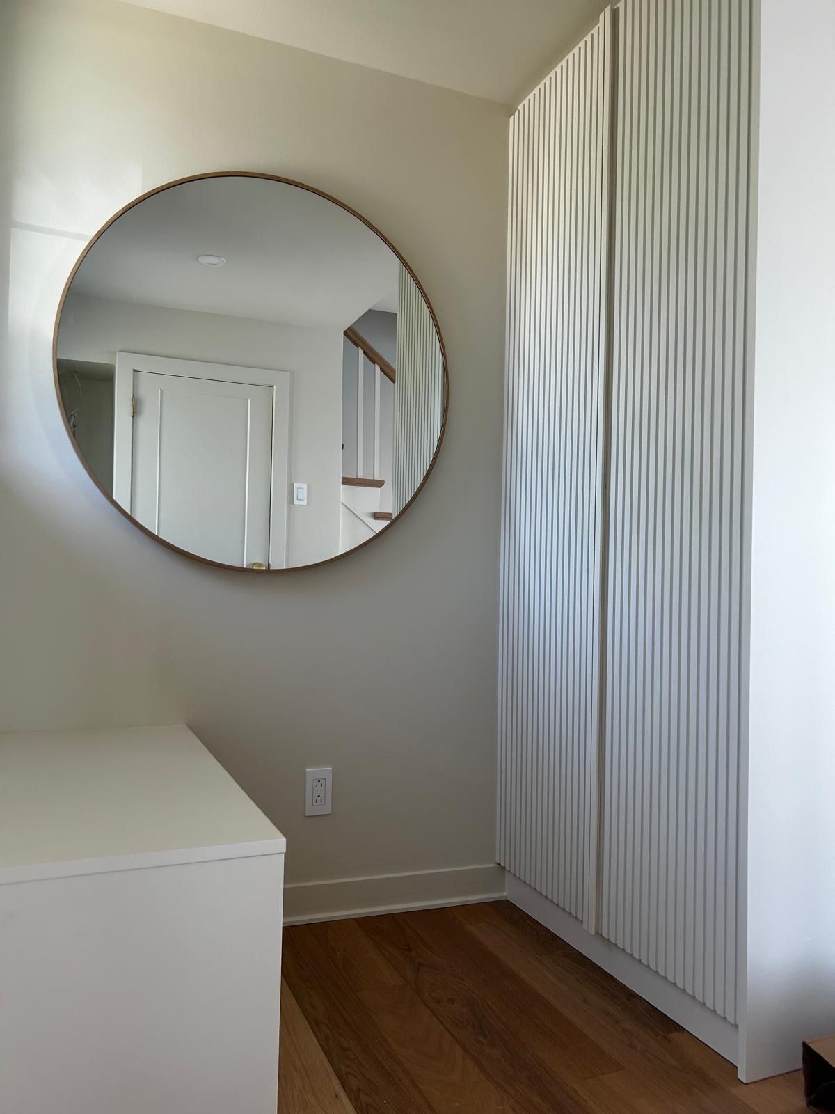 Une pièce avec un miroir rond sur le mur