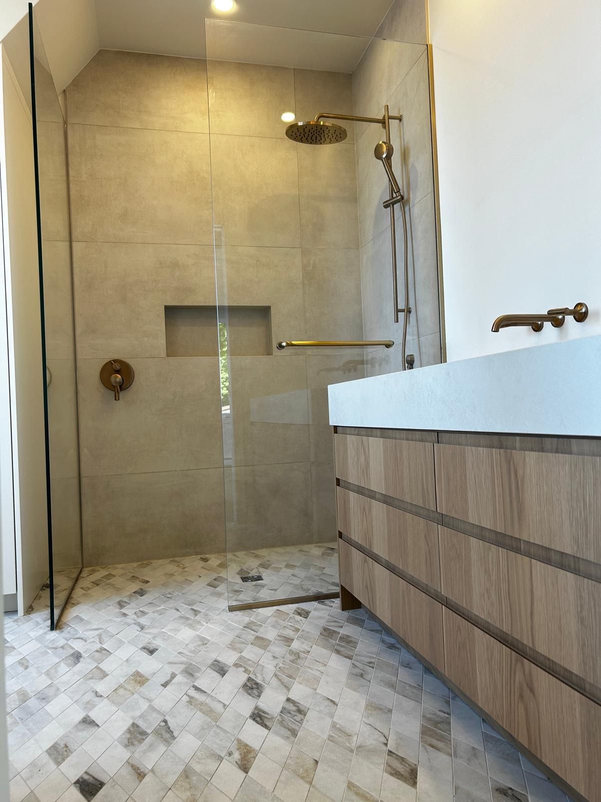 Une salle de bain avec une douche à l'italienne et un lavabo