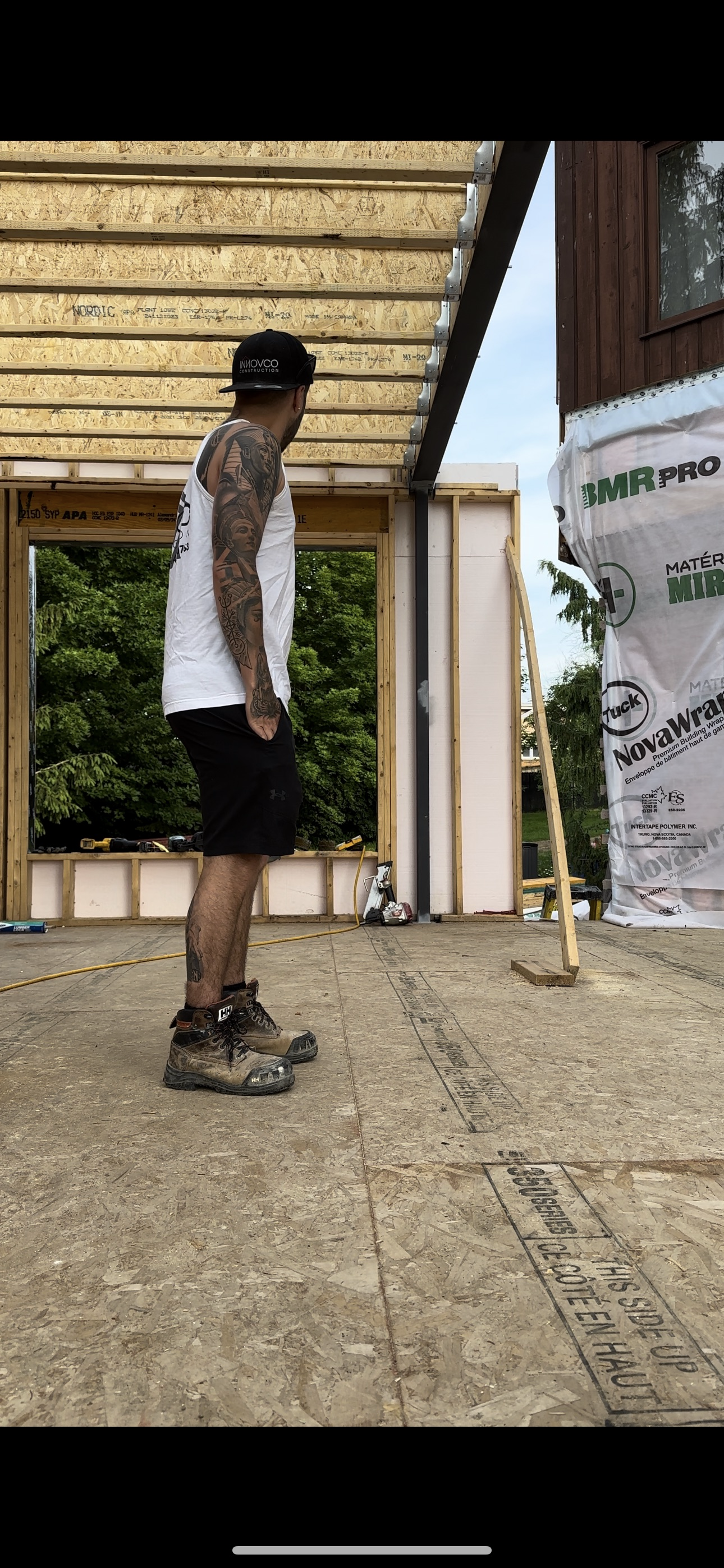 A man is standing in front of a building under construction.