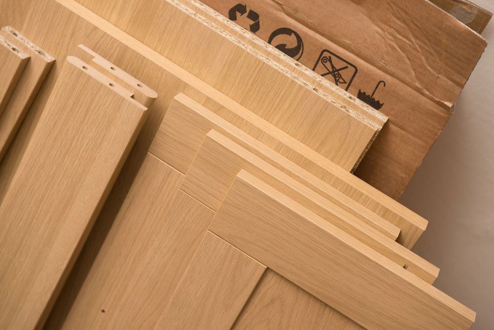 A Stack Of Wood Pieces Next To A Cardboard Box — Cut N Edge Panel Factory In Coolum Beach, QLD