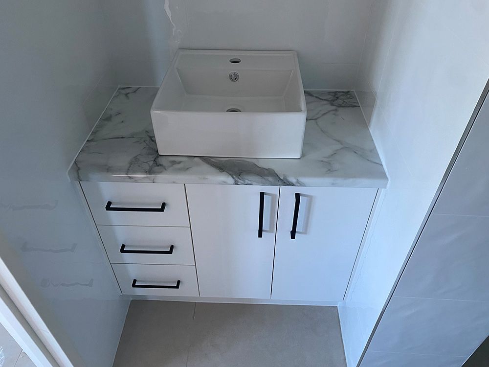 A Bathroom Sink Is Sitting On Top Of A Marble Counter Top — Cut N Edge Panel Factory In Coolum Beach, QLD