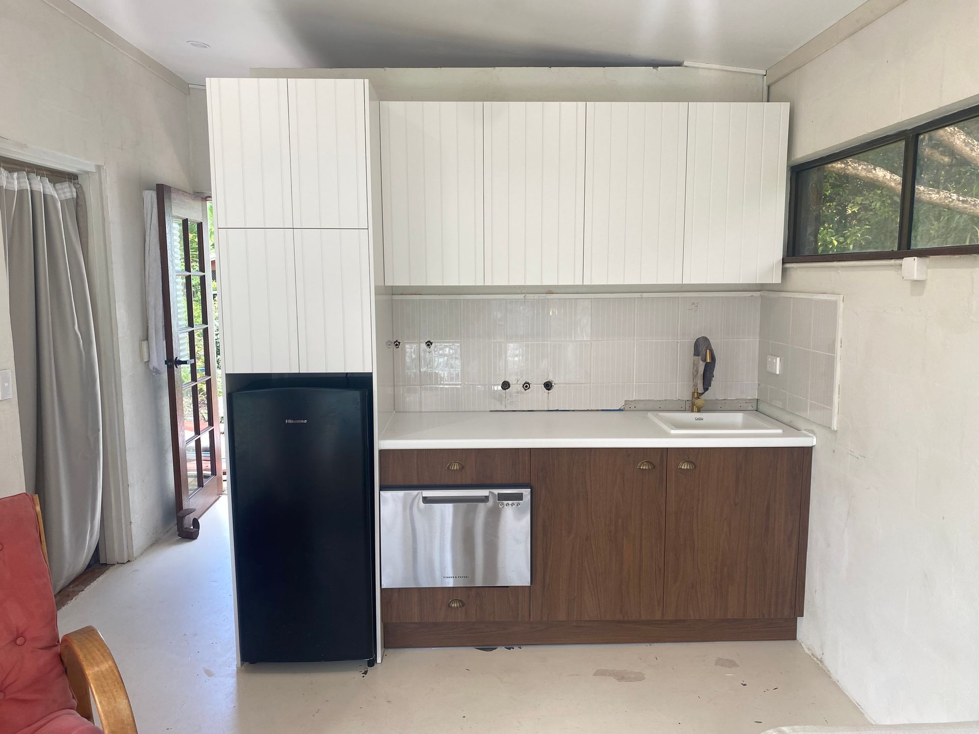 Small kitchen with white and brown cabinets, black refrigerator, and sink. — Cut N Edge Panel Factory In Coolum Beach, QLD