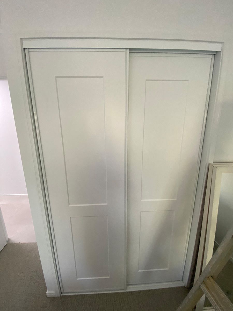 A White Closet With Sliding Doors In A Room Next To A Staircase — Cut N Edge Panel Factory In Coolum Beach, QLD
