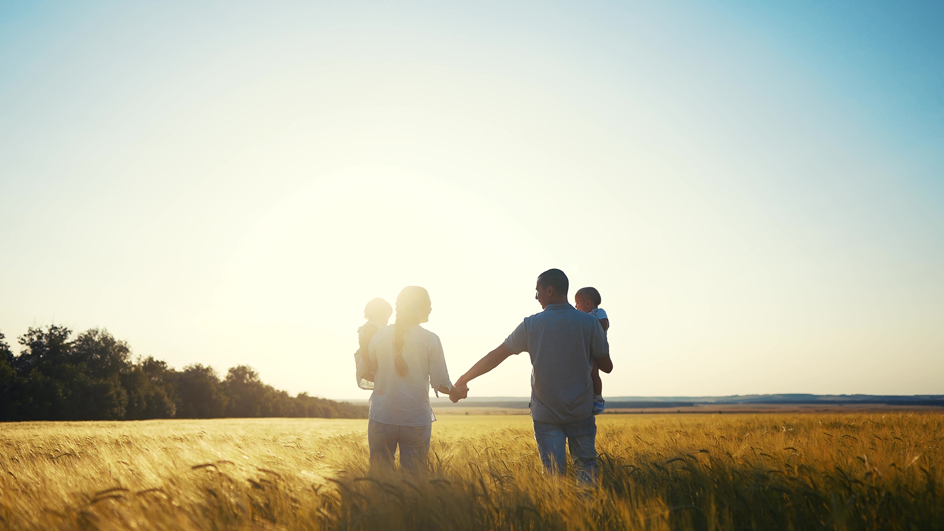 a family walking through a field with their arms outstretched