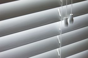 White horizontal blinds with two pull cords.
