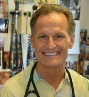 Smiling person wearing a stethoscope in a medical office setting