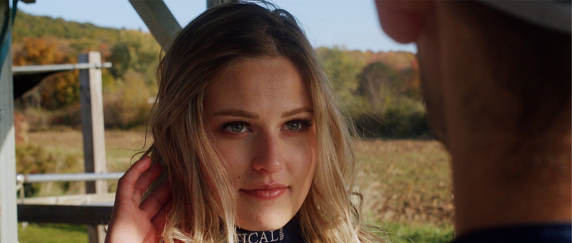 A man and a woman are looking at each other in a field.