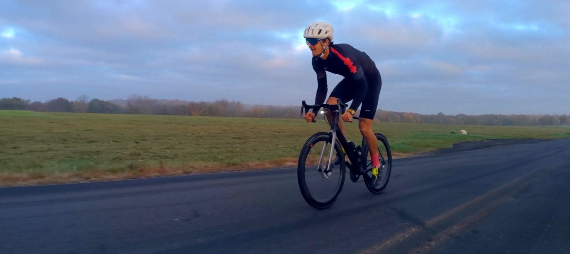 A man is riding a bike down a road.