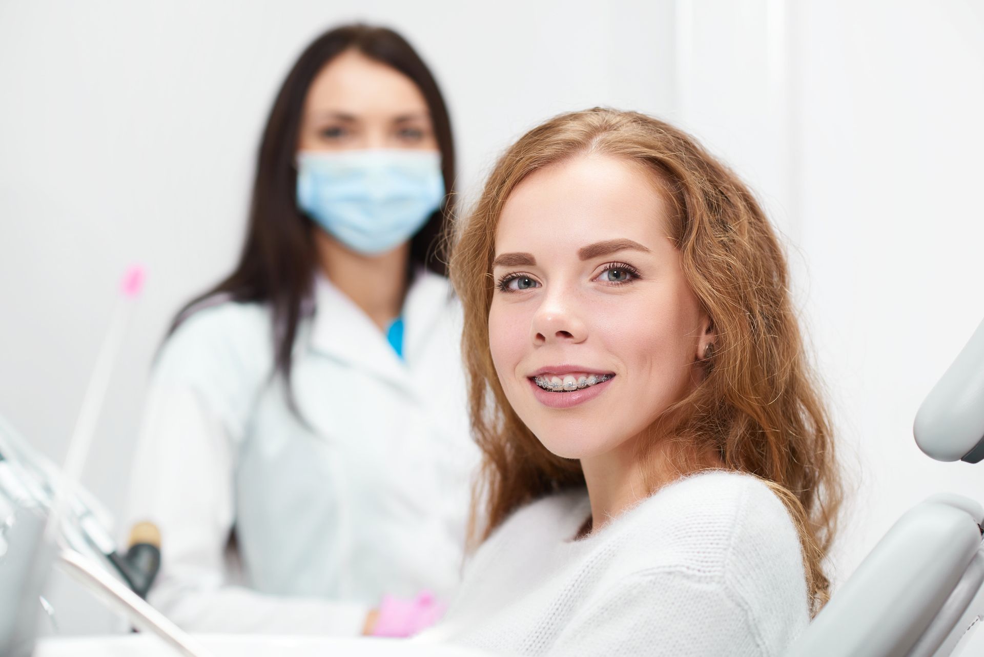 Patient sitting in dental chair during routine checkup with dentist in modern clinic.