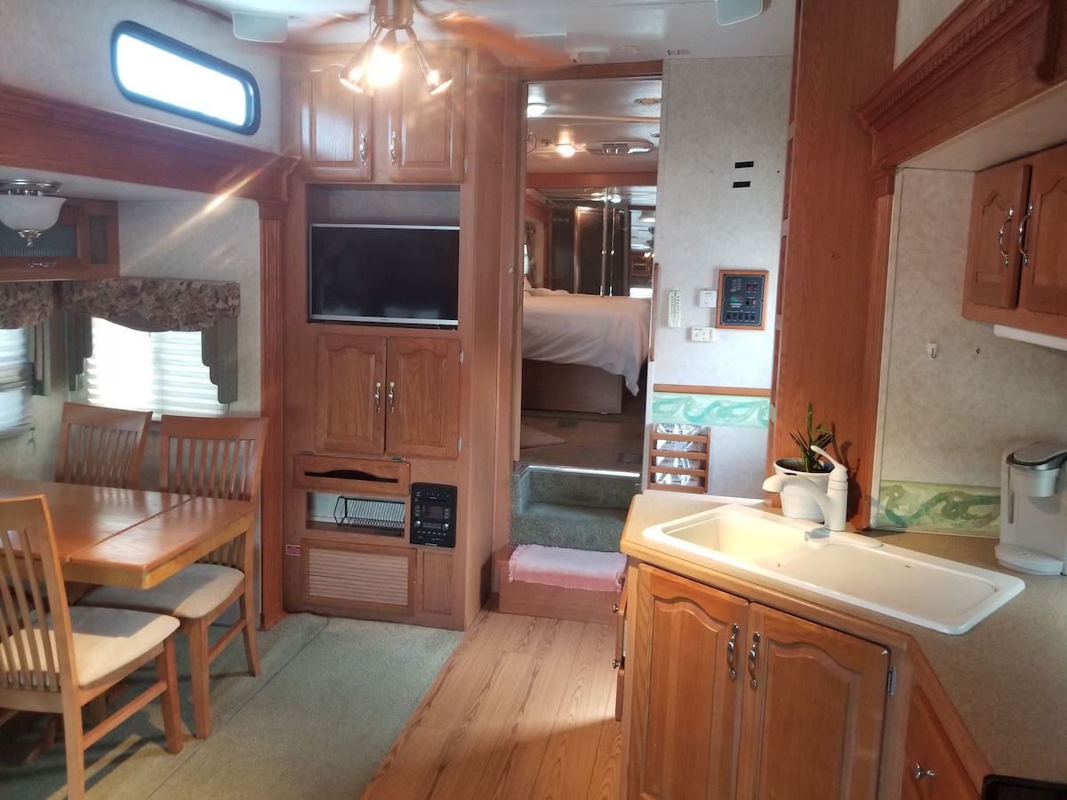 A kitchen with a sink a table and a television